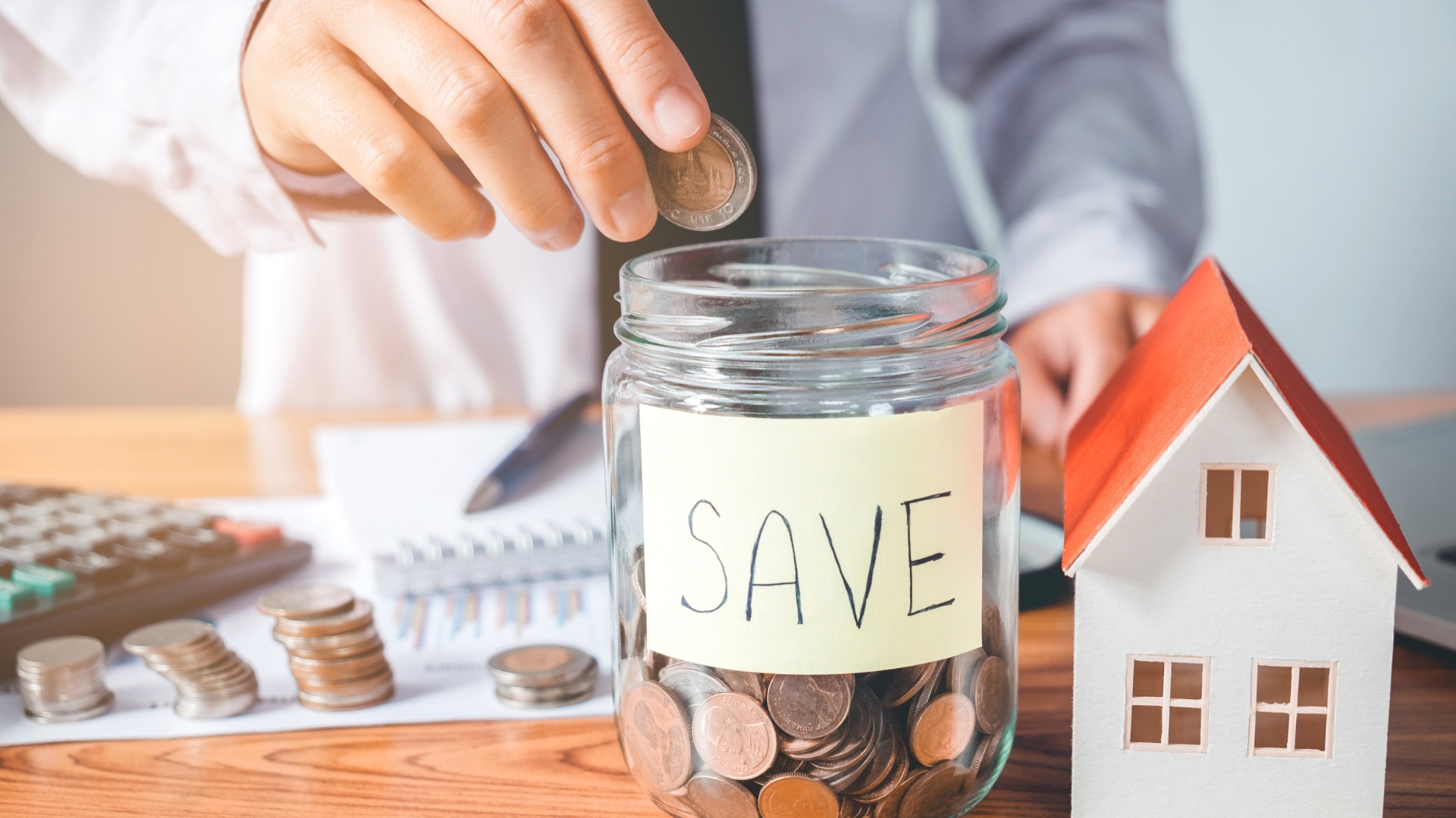 A man putting money in a jar the he saved from installing a new garage door opener