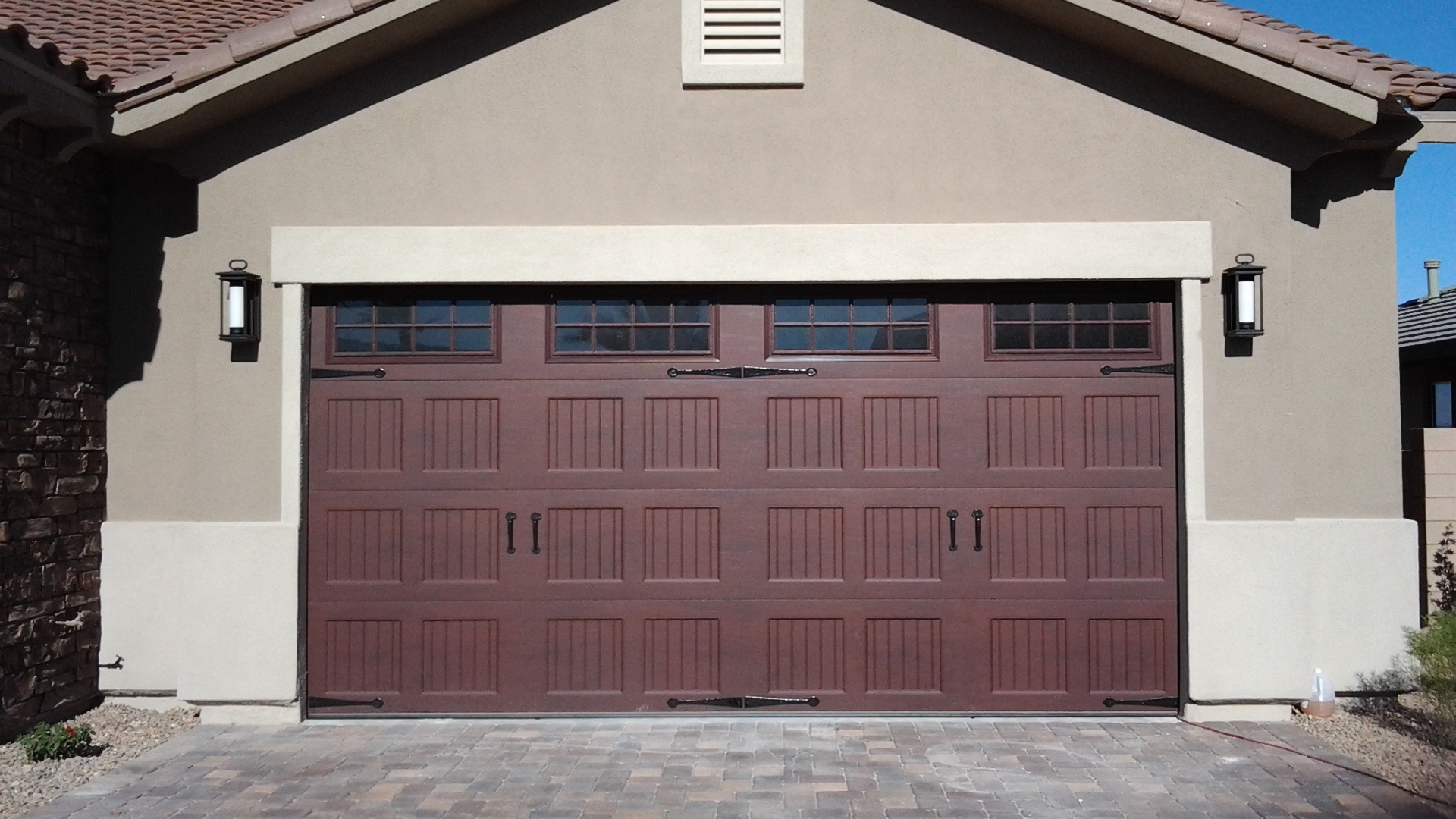 A brown double-car garage door with decorative hardware