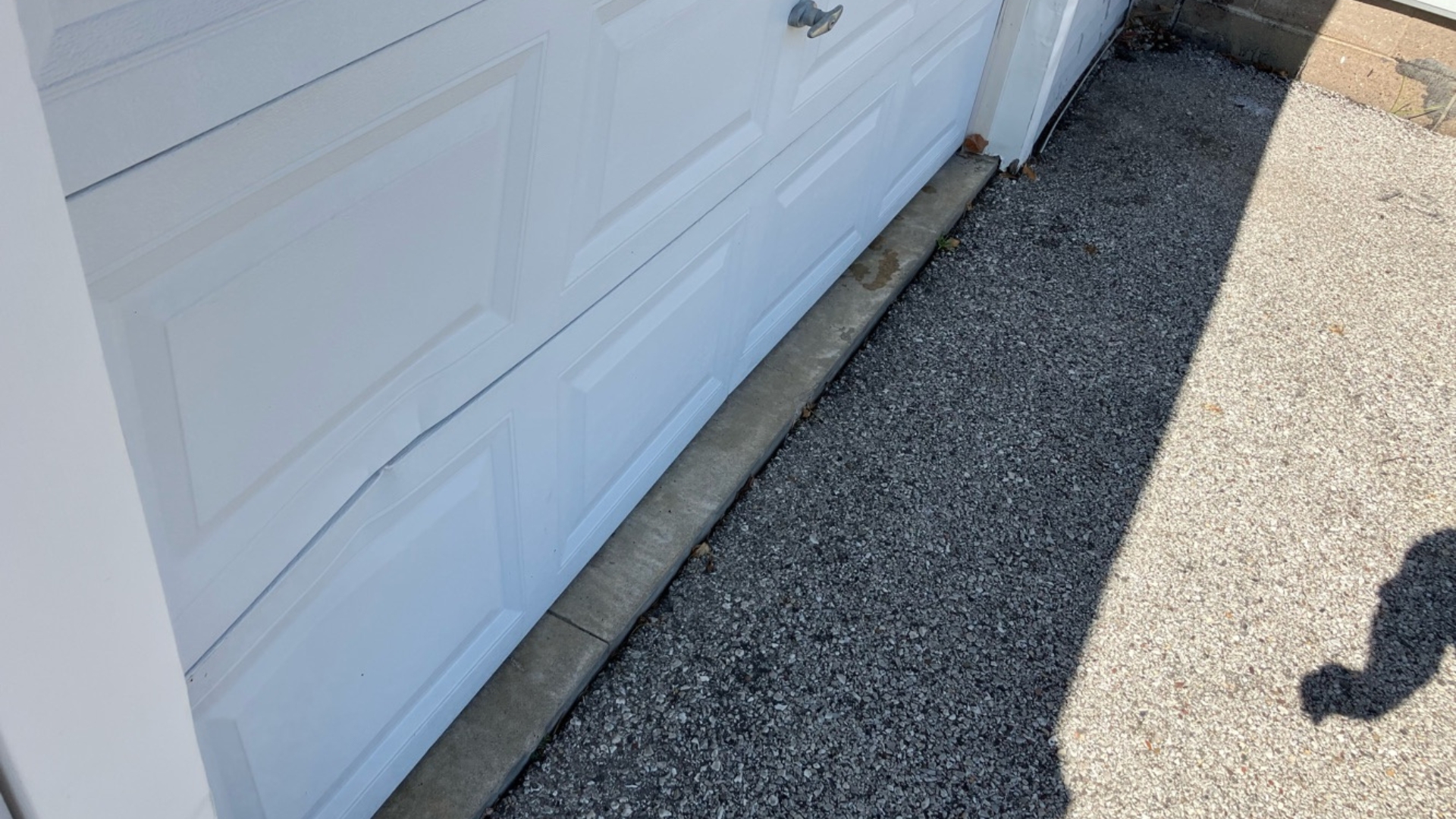 A white sectional garage door with bent panels