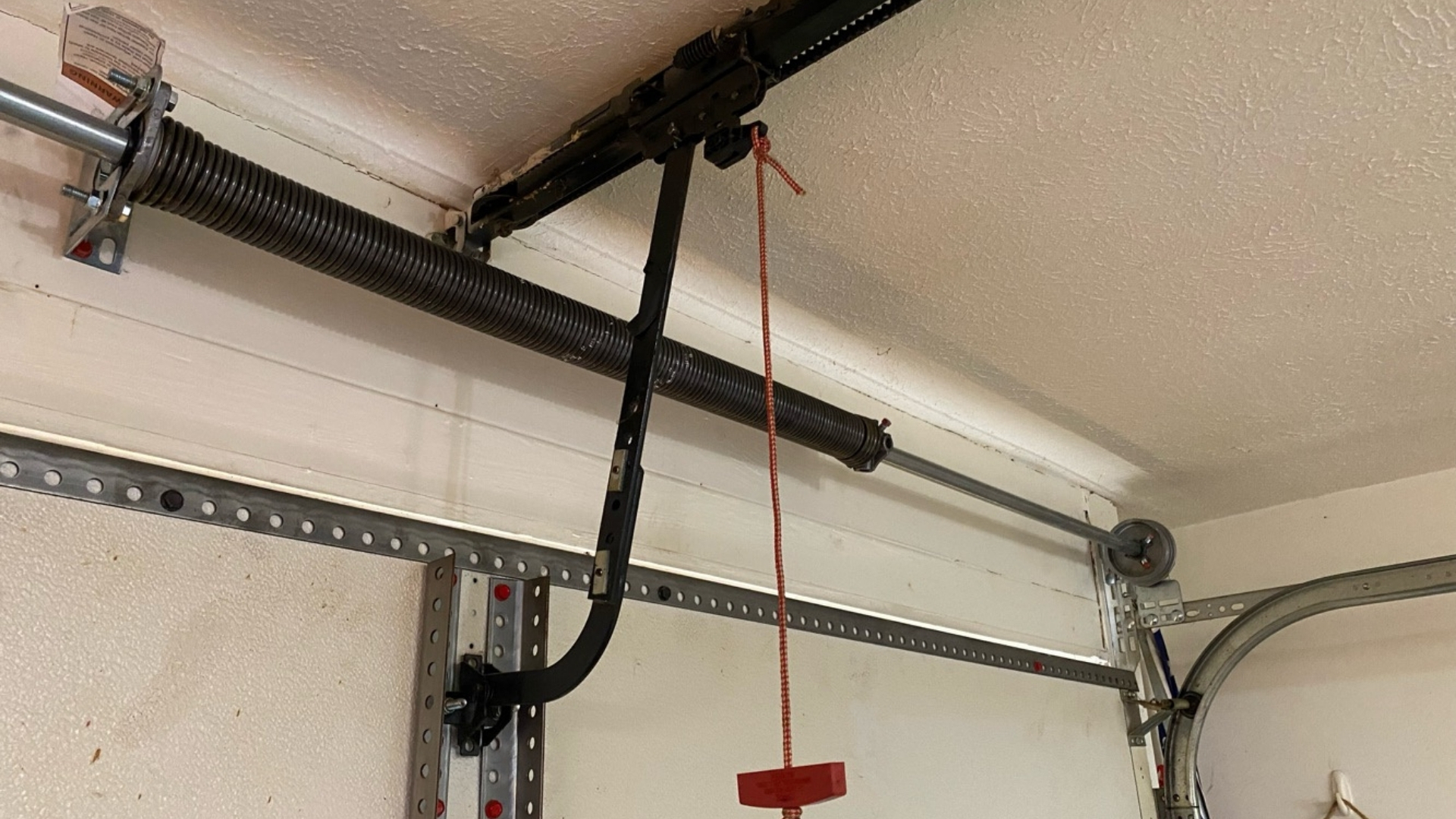 A torsion spring installed in a garage door system with emergency release cord