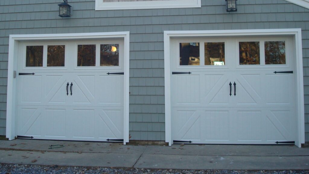 White residential garage doors with decorative handles and hinges