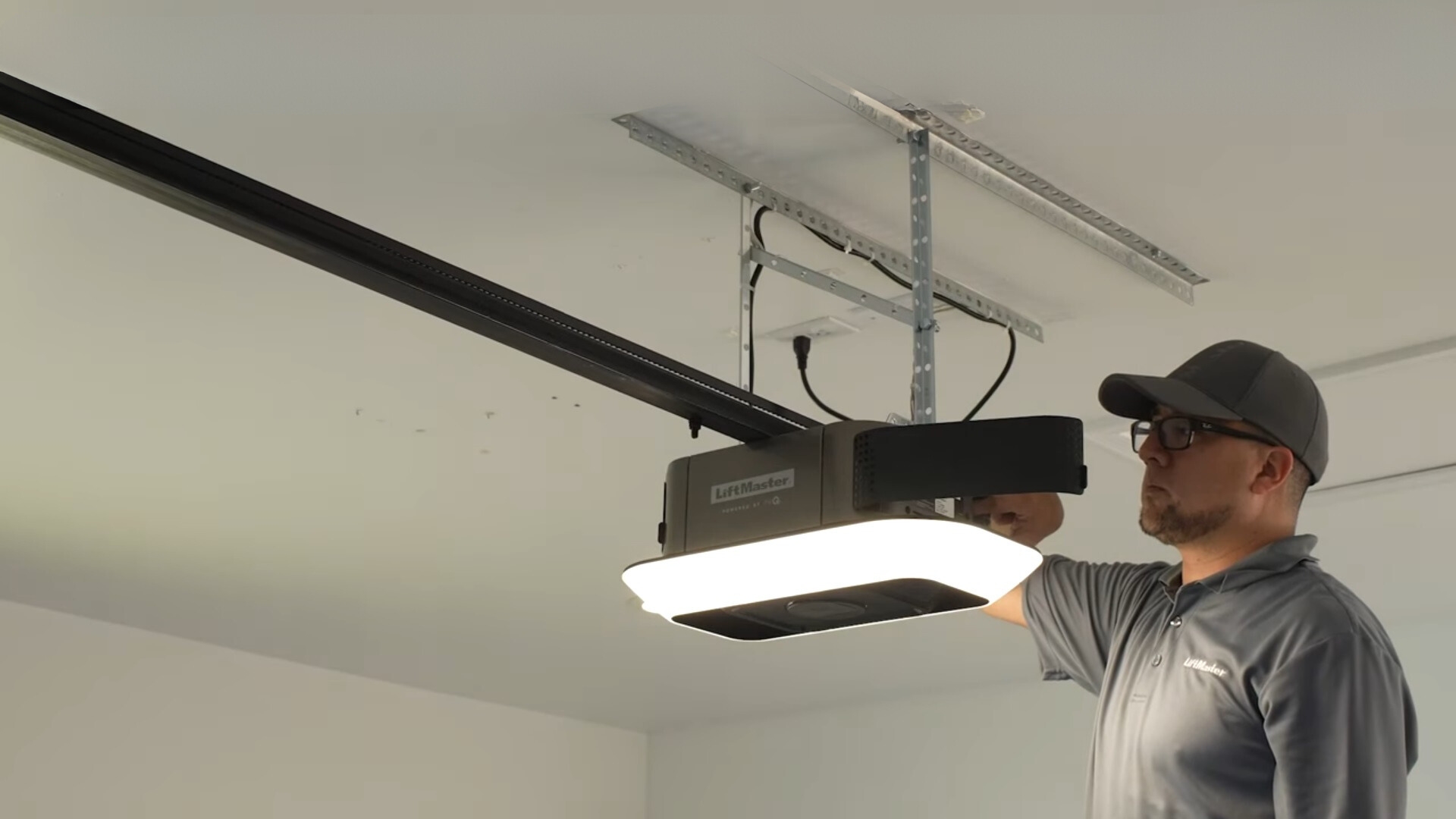 A technician installing a garage door opener