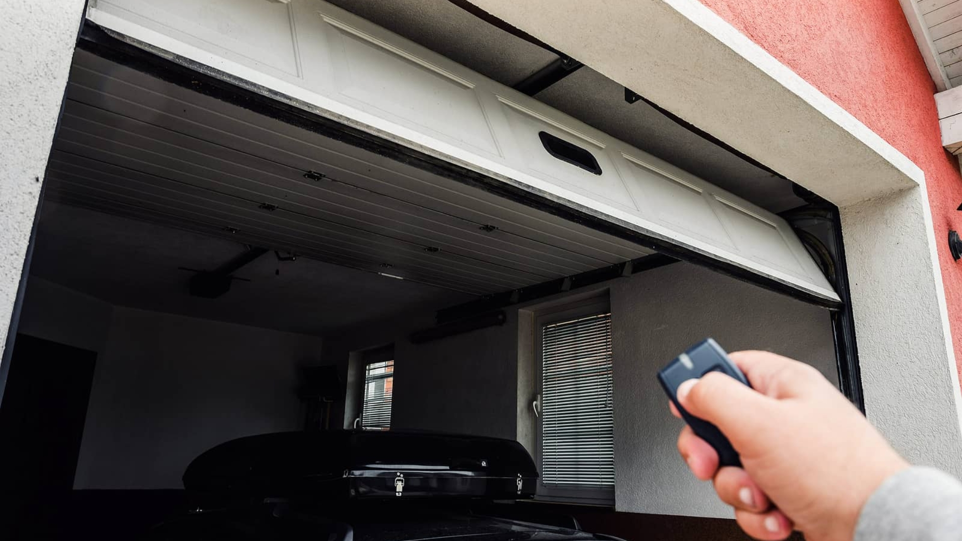 Opening a garage door with a remote to avoid mishap.