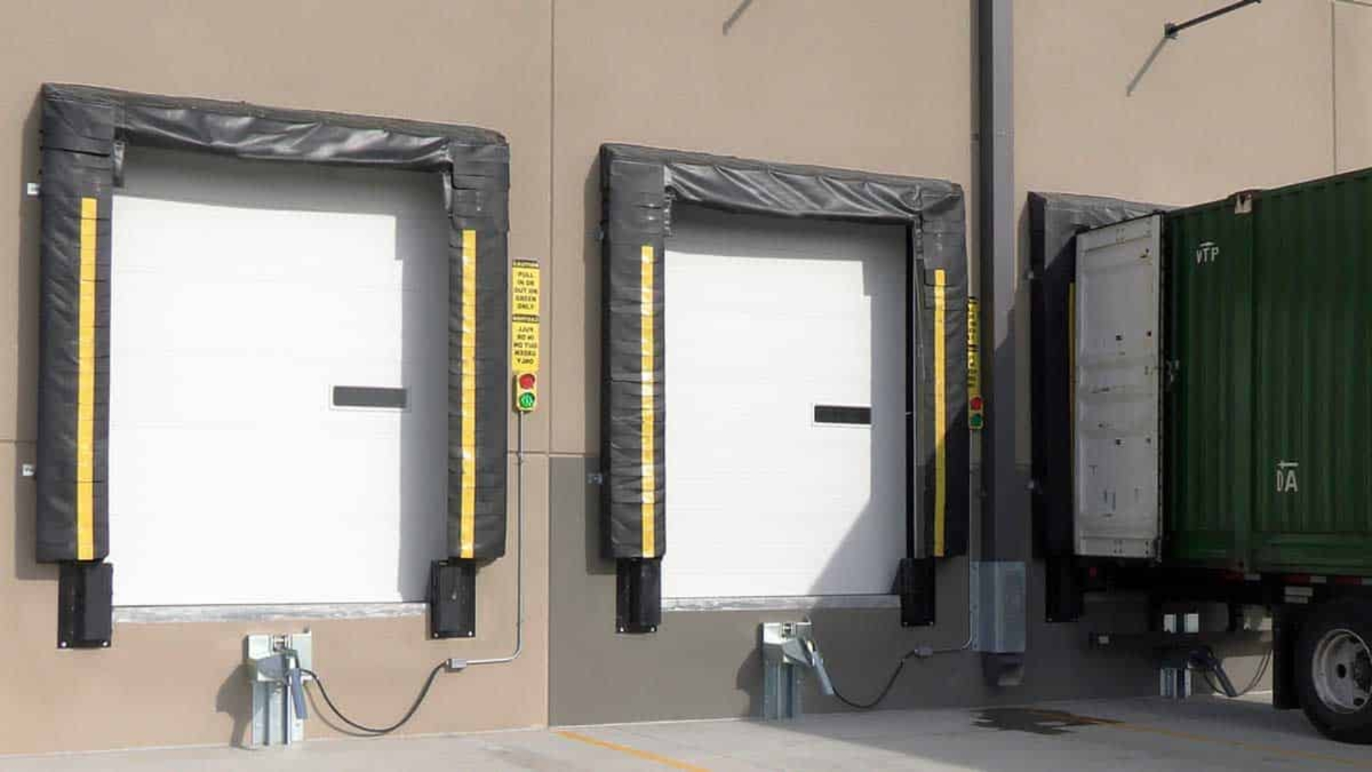 Close-up of loading dock doors with protective padding and a container docked.