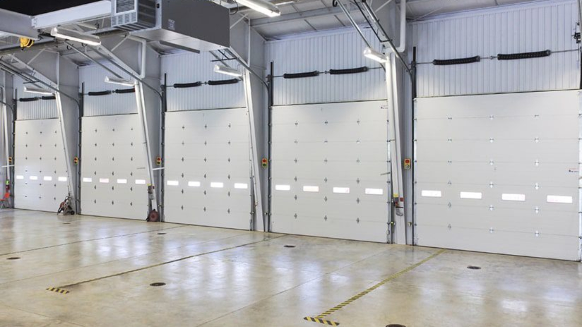 A row of heavy-duty commercial garage doors in an industrial facility