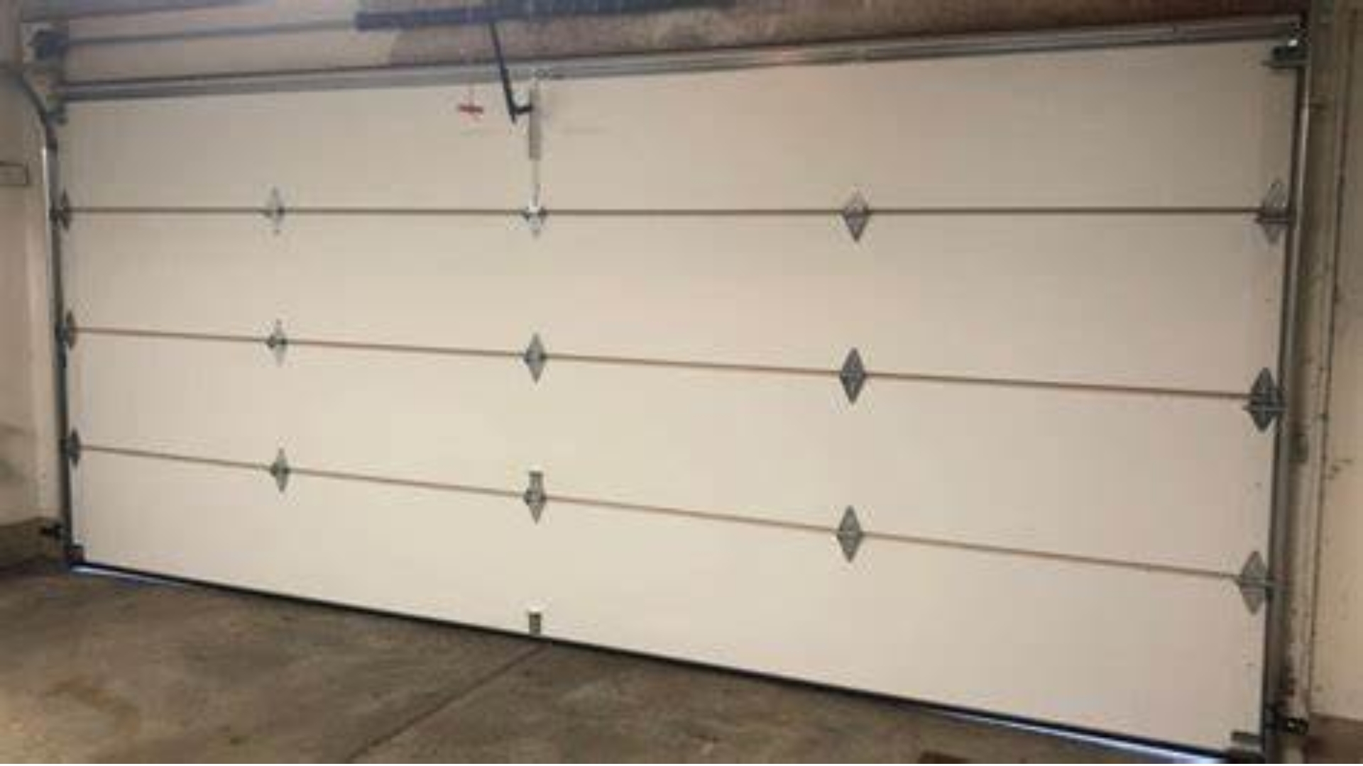 A wide white insulated garage door inside a residential home.